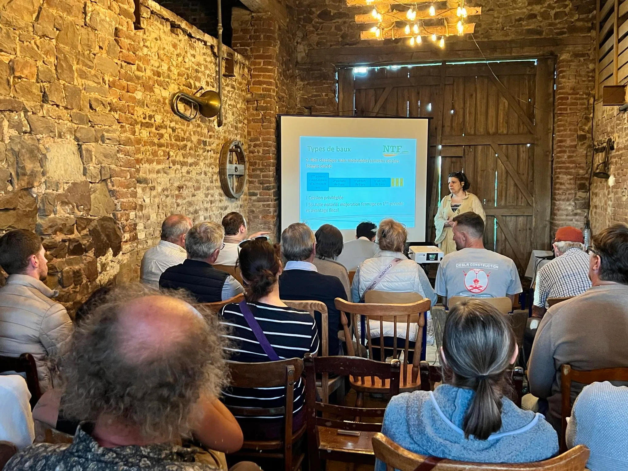 Des participants assistent à une présentation dans la grange